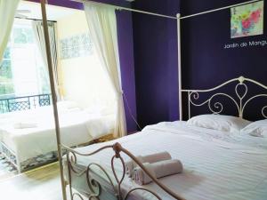 北冲瑞欧曼格帕克酒店的一间卧室设有两张紫色墙壁的床