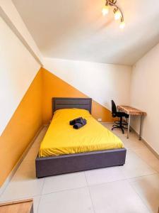 努美阿La Perle Azurée的一间卧室配有黄色的床和一张书桌