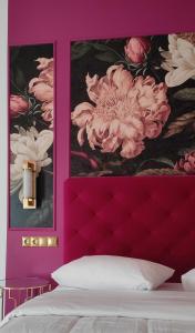 伊西翁L Suites The Writer's House的一间卧室,配有粉红色的墙壁和两张鲜花