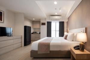 曼谷阿斯皮拉卢阿卢迪公寓的酒店客房,配有床和电视