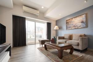 曼谷阿斯皮拉卢阿卢迪公寓的客厅配有沙发和桌子