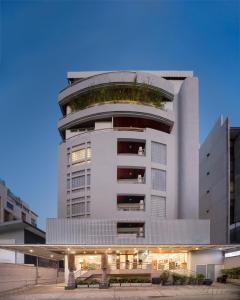 曼谷阿斯皮拉卢阿卢迪公寓的一座高大的白色建筑,上面有植物