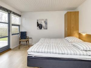 博托比Four-Bedroom Holiday home in Væggerløse 22的卧室配有床、椅子和窗户。