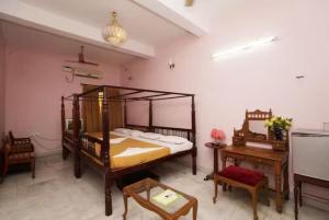蓬蒂切里Hotel Soorya Inn的一间卧室配有一张床、一张桌子和一张书桌