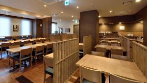 和歌山Hotel Route Inn Grand Wakayama Eki Higashiguchi的用餐室配有木桌和椅子