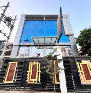 古瓦哈提JD Grand Inn的一座高大的建筑,有黑色和黄色的门