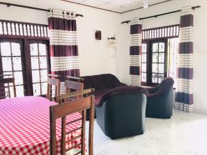 米瑞莎Family Villa Mirissa的客厅配有椅子、沙发和窗户