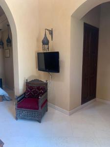 赫尔格达Nubia Gouna的电视位于带椅子的房间的角落