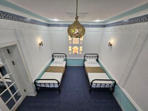 撒马尔罕Guest house Gula的一间设有四张床和吊灯的客房