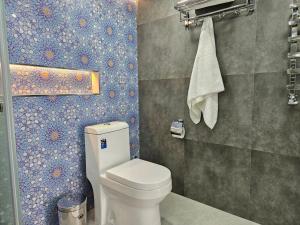 撒马尔罕Guest house Gula的一间带卫生间和瓷砖墙的浴室