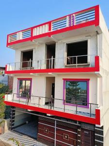 FaizābādSiya home stay的带阳台的红白色建筑