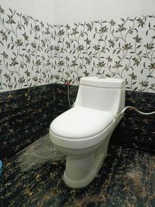 FaizābādSiya home stay的浴室设有白色卫生间,装饰有花卉壁纸