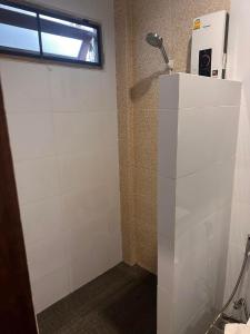 波普托Baan Yaimai Boutique Samui的带淋浴的浴室和白色瓷砖墙