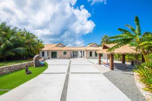 North SideThe Mastic Cana Luxury Cottage的前面有棕榈树的房子