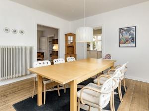HolebyHoliday home Holeby的一间带木桌和白色椅子的用餐室