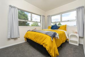 旺阿雷Riverside Retreat的一间卧室设有黄色的床和窗户。