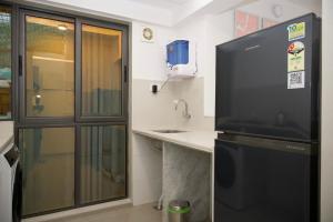 孟买Z Bliss Suites, BKC的一个带水槽的厨房和一台大电视