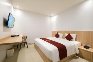 坎古ValStar Hotel Canggu的配有一张床和一张书桌的酒店客房