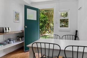 春溪Rosella's On Springbrook的厨房配有桌椅和绿门。