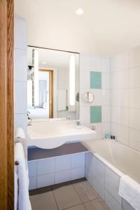 亚琛诺富特亚琛城市酒店的一间带浴缸和大镜子的浴室