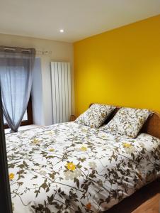 La Chapelle-aux-BoisL'Appart的一间卧室设有一张床和黄色的墙壁