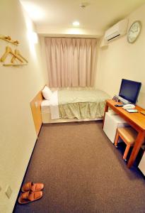 冈山Okayama Universal Hotel Annex 2的小房间设有一张床和一张带电脑的书桌