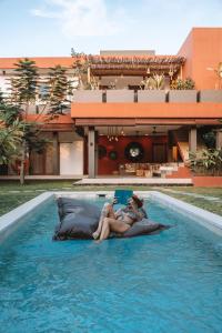 吉利阿尔Lasai Villas的两个人躺在游泳池的床上