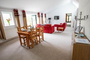 布德Treworgie Barton - Warner的客厅配有桌子和红色沙发
