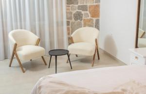 Gornji HumacNono Ban Hotel & Villa的卧室里配有两把椅子和一张桌子