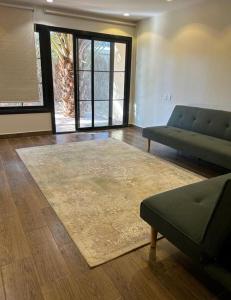 Madain Salehكوخ المزرعة的带沙发和地毯的客厅