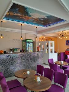 萨拉热窝Hotel PEKING的餐厅设有紫色桌椅和柜台