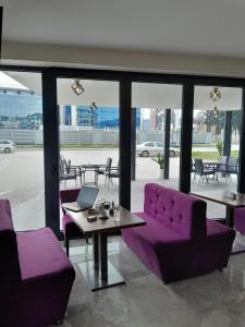 萨拉热窝Hotel PEKING的紫色的沙发以及带笔记本电脑的桌子