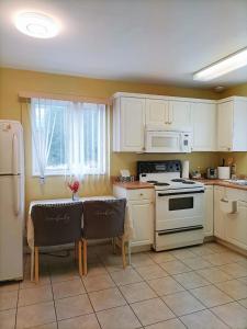温哥华Llt Fraser HomeAway的厨房配有白色家电和桌椅