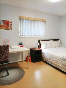 温哥华Llt Fraser HomeAway的一间卧室配有一张床、一张书桌和一个窗户。
