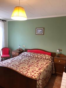Comano阿尔伯戈米拉蒙蒂酒店的一间卧室配有一张红色和棕色的棉被的床