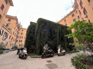 罗马La casa di Monica appartamento Ostiense Roma的三辆摩托车停在绿 ⁇ 前
