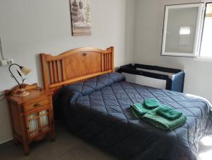 莫拉塔利亚Casa rural miralmonte的一间卧室配有一张带两张绿毛巾的床