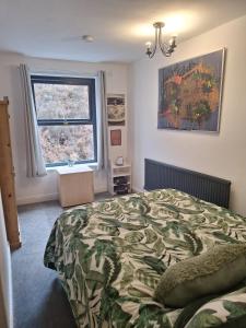 WalsdenTodmorden Bed & Breakfast - The Toothless Mog的一间卧室设有一张大床和一个窗户。