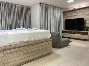 戈亚尼亚Lounge 22 Home Design的一间卧室配有一张床和一台平面电视