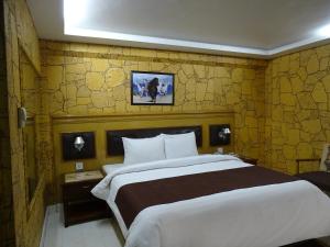卡拉奇Hotel One Karachi的一间卧室设有一张大床和黄色的墙壁