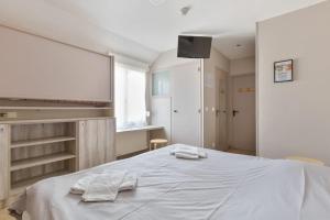 阿内勒Les Tourelles Village de vacances的一间卧室配有一张床,上面有两条毛巾