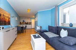 奥斯赛拜-屈隆斯博恩Möwen-Butze 8103 Yachthafenresidenz的带沙发的蓝色客厅和厨房