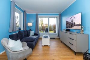 奥斯赛拜-屈隆斯博恩Möwen-Butze 8103 Yachthafenresidenz的蓝色的客厅配有沙发和椅子