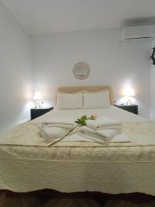 MouzákionMeltemaki的一间卧室配有一张带白色床单和两盏灯的床。