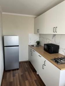 陶格夫匹尔斯Vienibas apartment的厨房配有白色橱柜和冰箱。