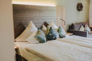 梅特拉赫Buchnas Landhotel Saarschleife的一间卧室配有带枕头的床