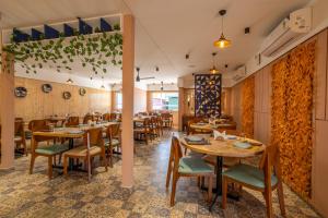 MundraClick Hotel Mundra的配有木桌和椅子的餐厅