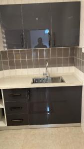 库马西My5 Hotel的厨房柜台设有水槽和镜子
