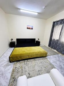 沙迦Sam Home的一间卧室配有一张黄色毯子床