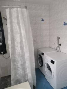 比勒费尔德Bob's Zimmer的带淋浴帘的浴室内的洗衣机